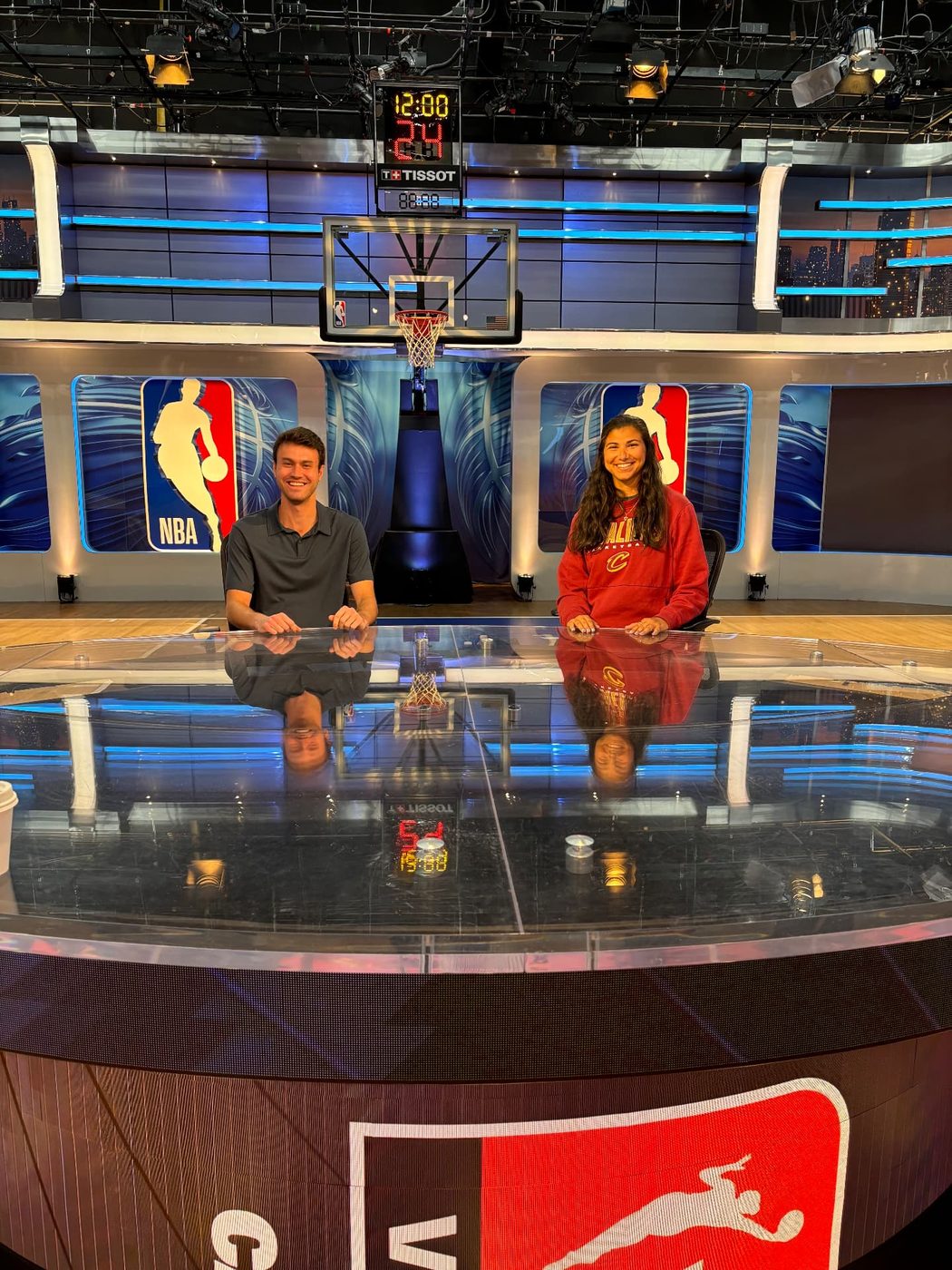 Reilly seated at the NBA studio desk beneath the shot clock and league logos